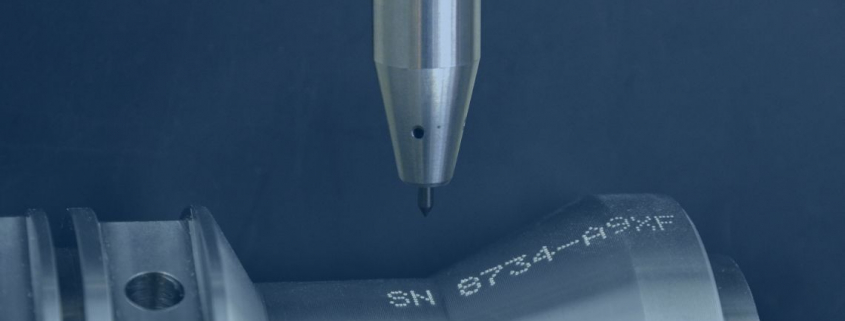 Primer plano de una herramienta de grabado realizando marcado de alta precisión en una pieza metálica.